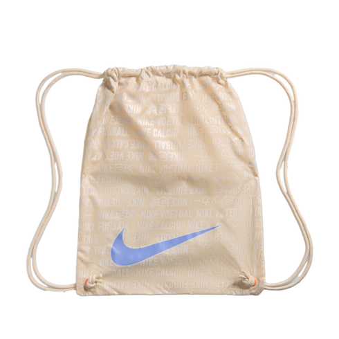 Cream-colored Nike drawstring bag with a repeating multilingual pattern of "Nike" and "soccer." A large light blue Nike swoosh is centered on the front.