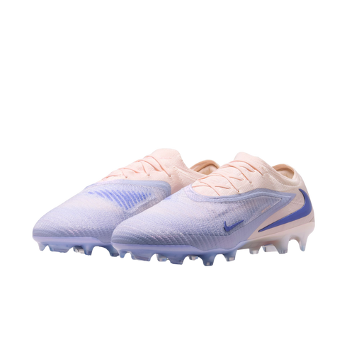 A pair of Nike soccer cleats in a pale pink and lavender gradient with blue accents on a black background.