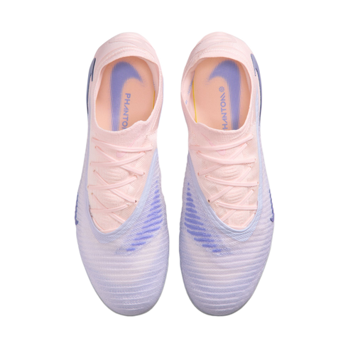 Top-down view of a pair of Nike Phantom soccer boots in pale pink and lavender against a black background.