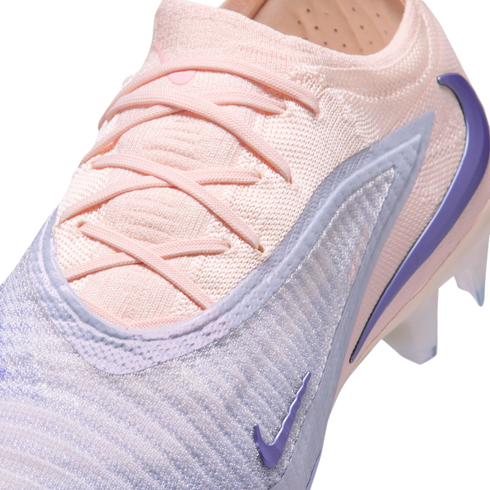 Close-up of a pale pink and lavender Nike soccer cleat with a textured Flyknit upper, crisscross laces, and purple Nike swoosh accents.