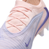 Close-up of a pale pink and lavender Nike soccer cleat with a textured Flyknit upper, crisscross laces, and purple Nike swoosh accents.