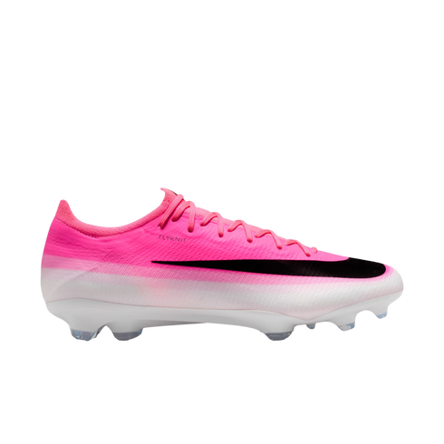 Side view of a pink and white Nike Flyknit soccer cleat featuring a large black swoosh and clear studs.