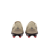 Back view of beige soccer cleats with red studs on a black background. The heels feature a circular logo and "Maestro" script.
