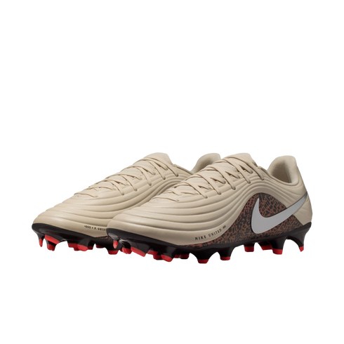 Nike Tiempo Legend 10 soccer cleats in beige with a leopard-print heel and bright orange-tipped studs, set against a black background.