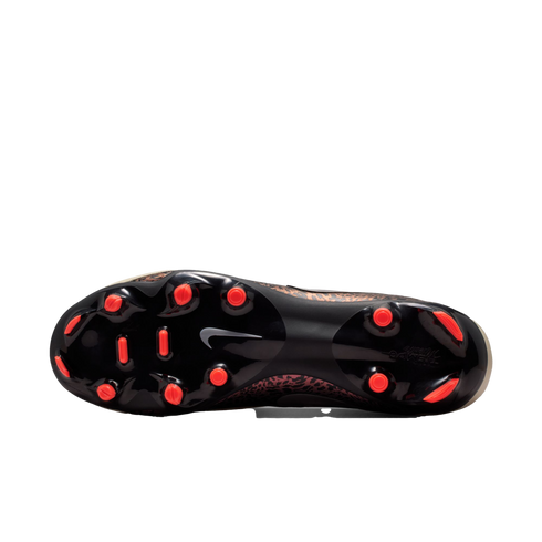 Underside view of a Nike soccer cleat with a black soleplate, bright orange studs, and a white swoosh logo. A brown leopard print pattern is visible along the edges of the upper.