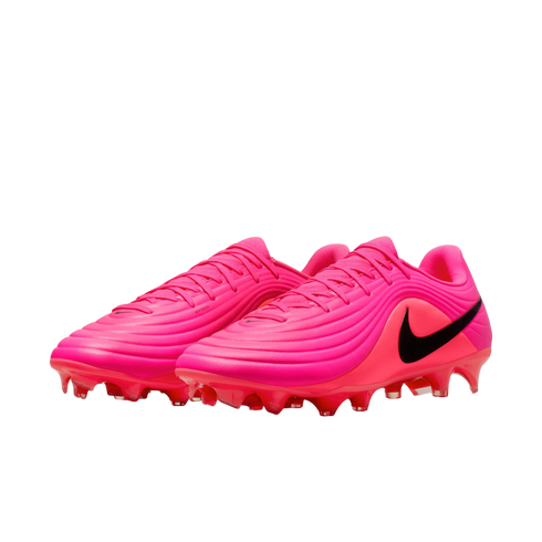 A pair of vibrant pink Nike soccer cleats featuring a ridged, textured upper and a prominent black swoosh on the side, set against a plain white background.