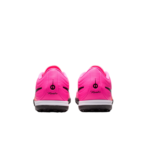 Rear view of two vibrant pink soccer shoes with black "Maestro" branding on the heels and black soles, centered on a white background.