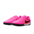 A pair of bright pink Nike turf soccer shoes featuring a textured upper, a black swoosh logo, and a black rubber outsole with traction nubs.