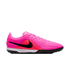 A side view of a bright pink Nike turf soccer shoe featuring a black swoosh, textured wavy upper, white midsole, and a black studded rubber outsole.