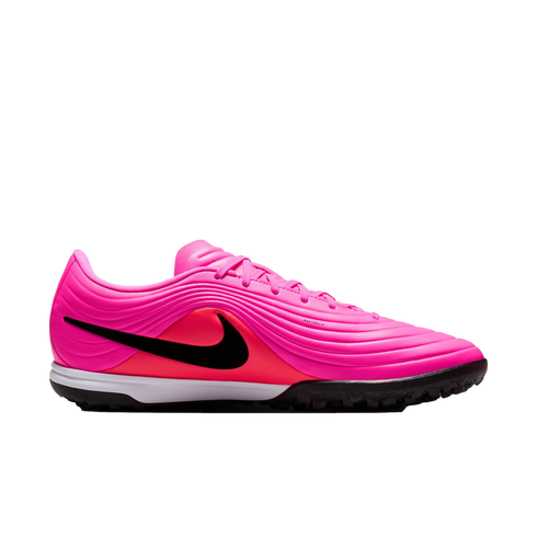 A bright pink Nike turf soccer shoe featuring a black swoosh, orange detailing, and a black studded outsole on a plain white background.