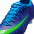 Close-up of a blue Nike soccer cleat with light blue laces, a bright green swoosh, and a dark blue LEGO brick pattern on the upper.