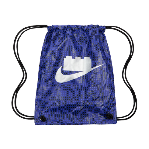 A blue drawstring bag with a LEGO stud pattern. A white Nike swoosh in the center features a LEGO brick top.