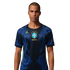 A man in a dark blue Brazil football jersey with a yellow Jordan logo and CBF crest, featuring blue vertical patterns, against a black background.