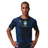 Man in a navy blue Brazil soccer jersey featuring a yellow Jordan logo and team crest, standing with hands on hips against a black background.