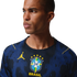 A man in a blue Brazil soccer jersey with yellow Jordan and CBF logos, looking sideways against a black background.