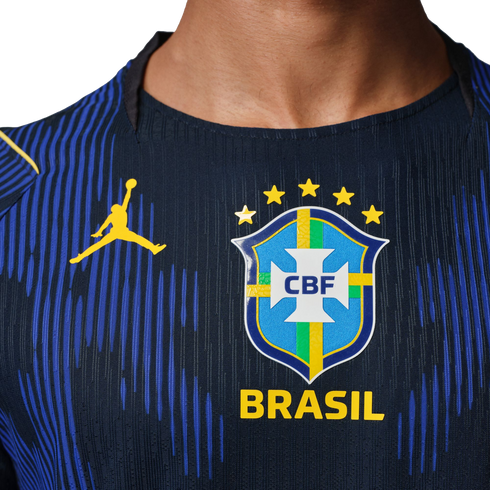 Close-up of a dark blue Brazil soccer jersey with a yellow Jordan logo and the CBF crest with five stars above the word "BRASIL".