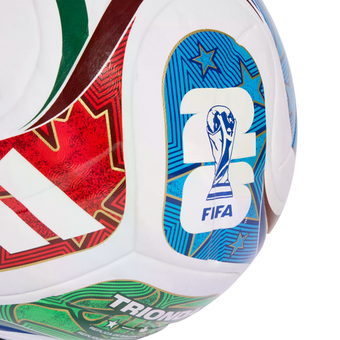Close-up of a white Adidas soccer ball featuring the FIFA World Cup 2026 logo, red and green patterned stripes, and "TRIONFO" text.