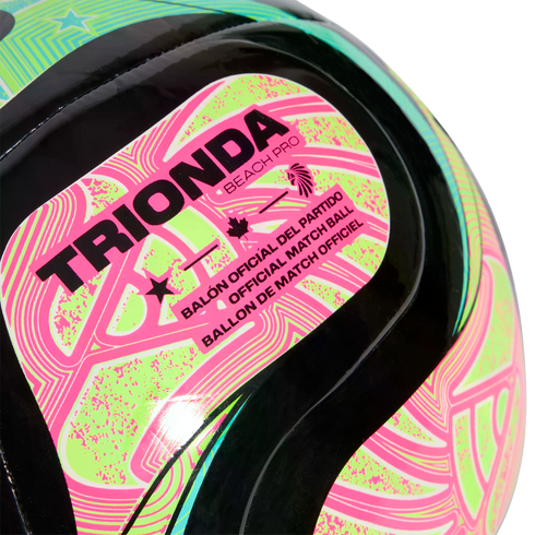 Close-up of a Trionda Beach Pro official match ball featuring neon pink and green patterns on a black surface.