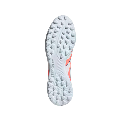 Light blue and orange rubber outsole of an Adidas Predator turf soccer shoe with traction studs on a black background.