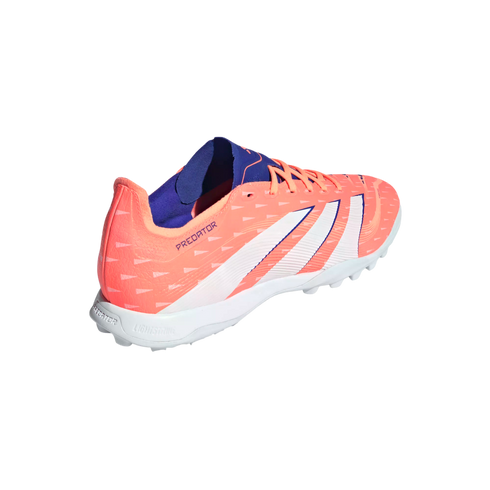 A bright coral Adidas Predator soccer shoe featuring white stripes and a blue interior, designed for turf play with a white studded sole.
