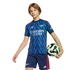 A young person wearing a blue Arsenal soccer kit with a lightning bolt pattern, holding a soccer ball under their arm against a black background.