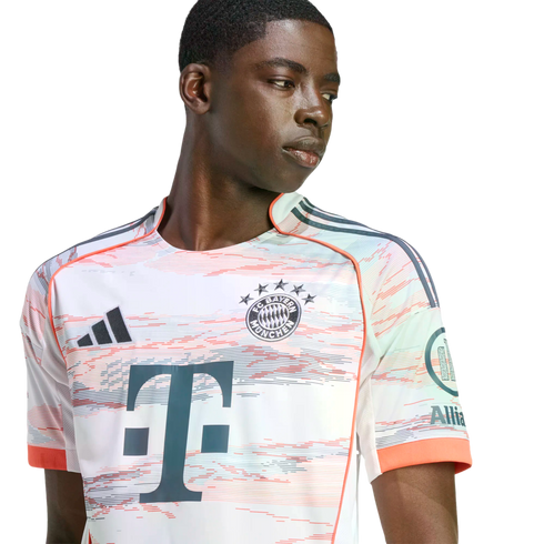 A young man wearing a white, peach, and mint green FC Bayern Munich soccer jersey against a white background.