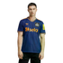 A man models a navy blue Newcastle United soccer jersey with orange trim, featuring thin vertical stripes, the Sela sponsor logo, and Adidas trefoil logo, against a black background.