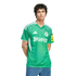 A man wearing a green Newcastle United football jersey with white details and a "sela" sponsor logo, paired with blue jeans against a black background.