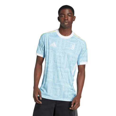 A young Black man models a light blue patterned Juventus soccer jersey with white trim against a plain white background.