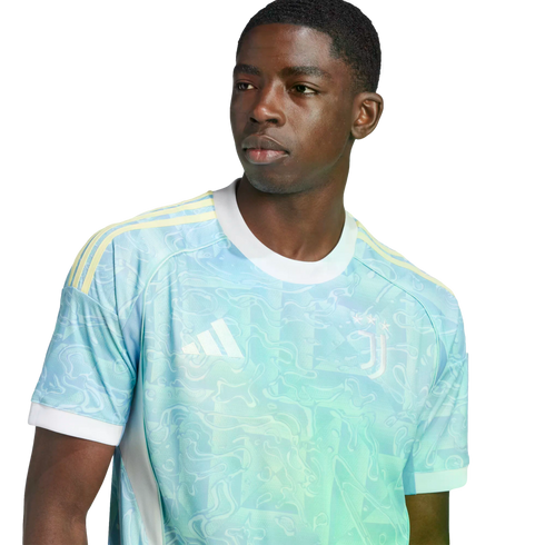 A young man wearing a light blue and teal patterned Juventus soccer jersey with yellow shoulder stripes and a white collar.