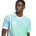 A young man wearing a light blue and teal patterned Juventus soccer jersey with yellow shoulder stripes and a white collar.