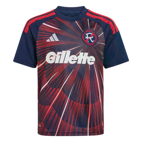 A navy and red youth soccer jersey with a sunburst graphic. Features a white Gillette logo, Adidas logo, and team crest. Navy sleeves have red stripes.