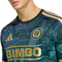 Close-up of a Philadelphia Union soccer jersey with a gold "BIMBO" logo, team crest, and a teal background patterned with historical text.