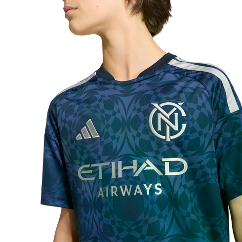 Person wearing a navy and teal New York City FC soccer jersey with a circular geometric pattern, Adidas logo, and Etihad Airways sponsor text.