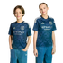 Two children wear matching navy patterned New York City FC soccer jerseys with silver Etihad Airways logos and blue jeans, standing against a black background.