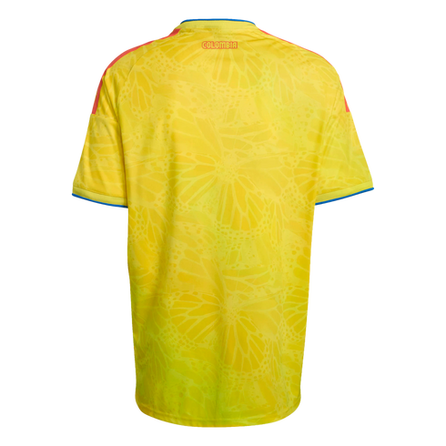 Back of a yellow Colombia soccer jersey with a subtle butterfly wing pattern, red shoulder stripes, and "COLOMBIA" in red text near the collar.