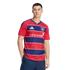 A man modeling a red and blue striped FC Dallas soccer jersey with a white sponsor logo against a black background.