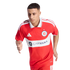 A male soccer player in a red Chicago Fire FC jersey with "CARVANA" logo, captured in a running pose against a black background.