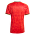 Back view of a red soccer jersey with a subtle tonal trident pattern, yellow shoulder stripes, and black and yellow trim on the collar and sleeve cuffs.