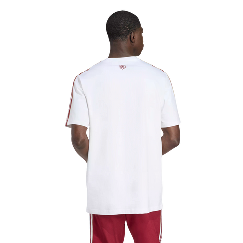 Rear view of a man wearing a white t-shirt with red shoulder stripes and red shorts against a black background.