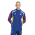 A man with buzzed blonde hair wearing a blue Adidas Arsenal FC tracksuit with red stripes and yellow/light blue accents, posed against a black background.