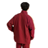 Rear view of a person with short black hair wearing a maroon tracksuit with yellow stripes on the sleeves against a white background.