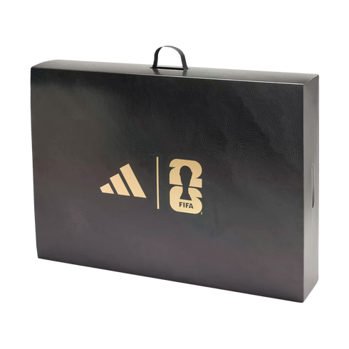 A black rectangular carrying case with a top handle features gold Adidas and FIFA World Cup 26 logos. The box has a subtle, intricate pattern on its surface.