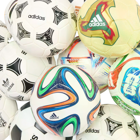 A pile of various Adidas soccer balls with different designs and patterns, including some from past World Cup tournaments.