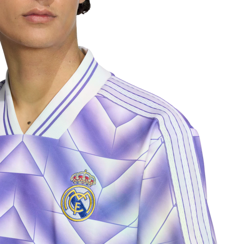 Close-up of a person wearing a purple Real Madrid soccer jersey with a geometric pattern, white stripes on the shoulders, and the team crest on the chest.