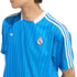 A person wearing a blue Real Madrid soccer jersey with white pinstripes and the Adidas trefoil logo.