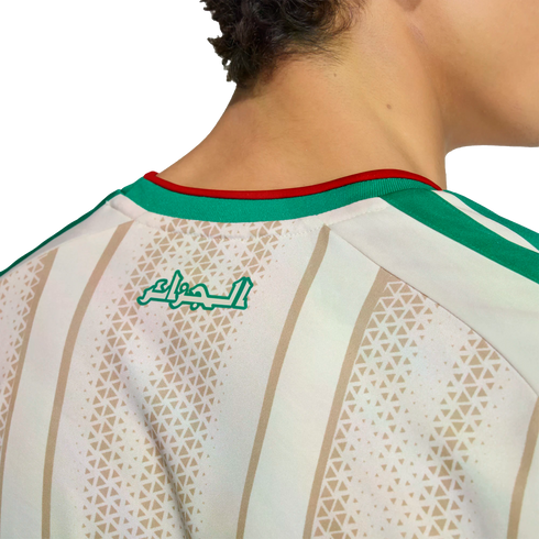 Back view of a person wearing an Algerian national football team jersey with "Algeria" in Arabic script, white and gold stripes, and a green and red collar.
