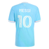 Back of a light blue soccer jersey with 'MESSI' and number '10' in white. It has pink accents on the sleeves and collar and 'Freedom to Dream' printed at the top center.