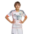 A young boy wearing an Adidas FC Bayern Munich away football kit stands with hands on hips against a white background.