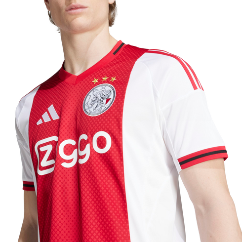Close-up of a person wearing an official red and white Ajax Amsterdam home jersey with the club crest and Ziggo sponsor logo.
